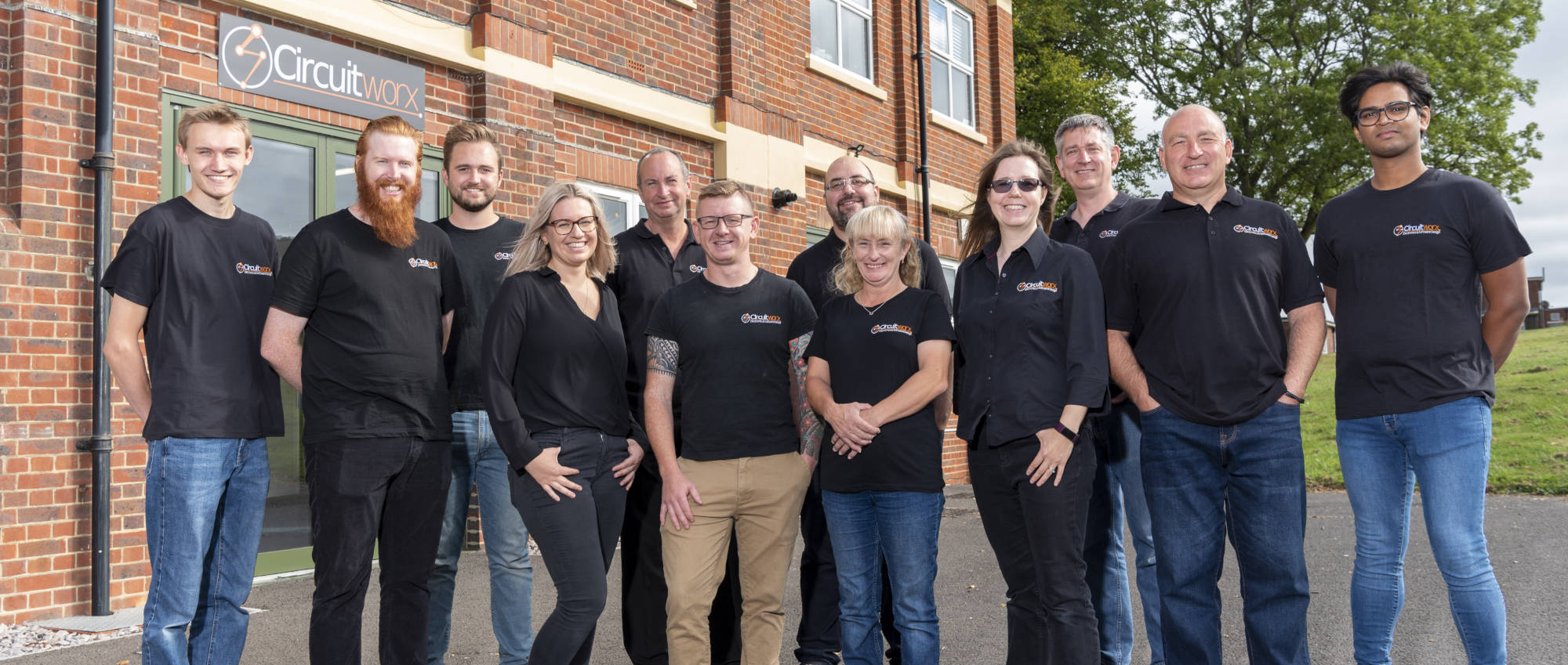 Group shot of CircuitWorx team standing outside office building