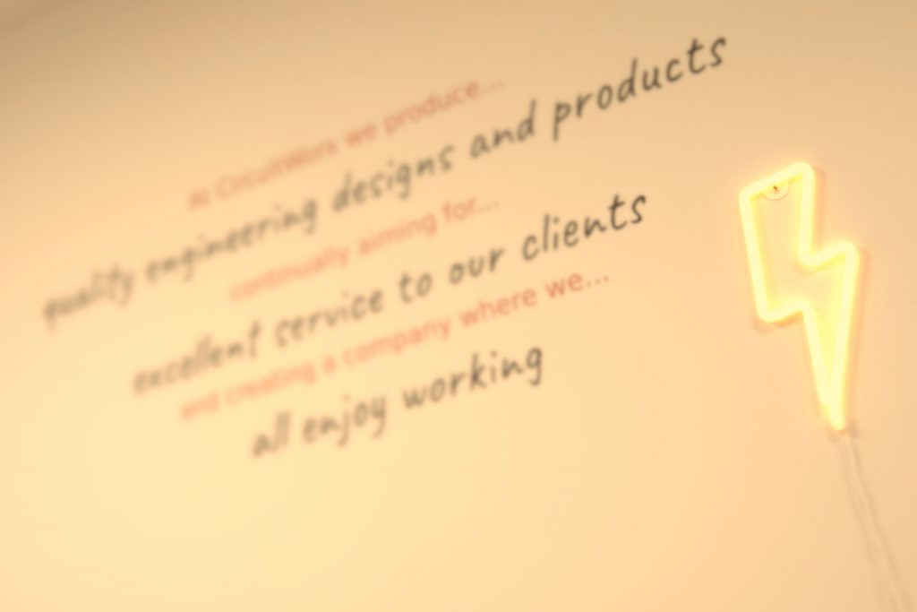 CircuitWorx quality statement text printed on office wall with LED lightning flash